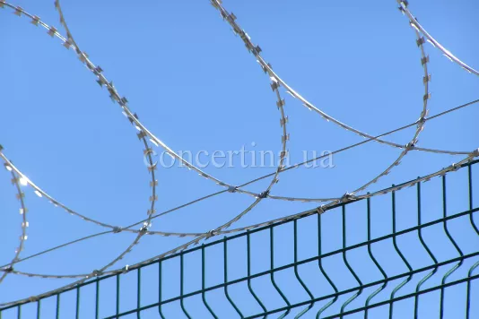 Плоский барьер безопасности Концертина на металлическом заборе